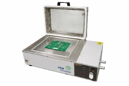 The reflow oven with its hood open and a PCB placed on the hotplate